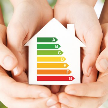 This graphic shows two pairs of hand cradling a model of a house with colour symbols showing various energy ratings.